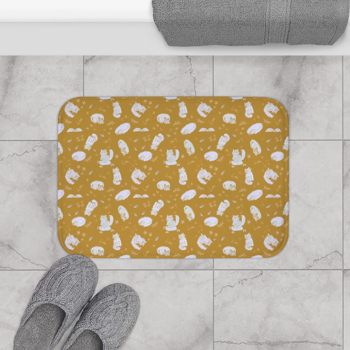 Mustard yellow bath mat featuring a cozy repeating pattern of sleeping and fluffy cats, books, stars, leaves, and handwritten words on a warm golden background, perfect for cat lovers and cozy home décor.