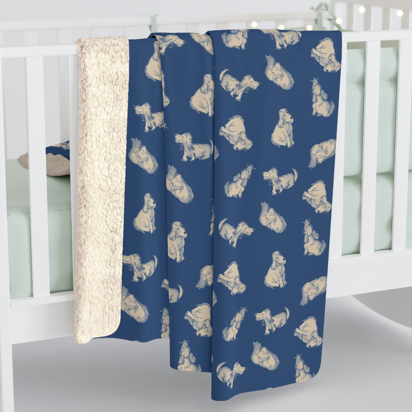 Blue crib sheet with dog pattern draped over a crib