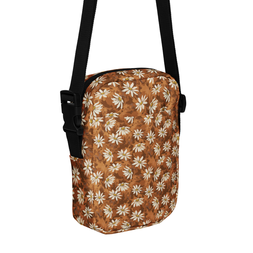 Daisy-scatter on textured warm browns bag with a black strap on a white background