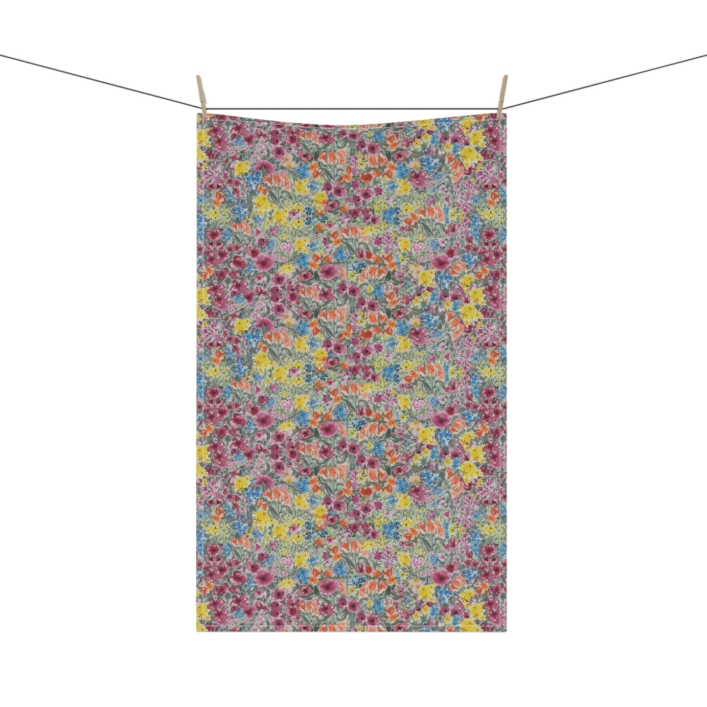 Floral patterned towel hanging on a line against a white background