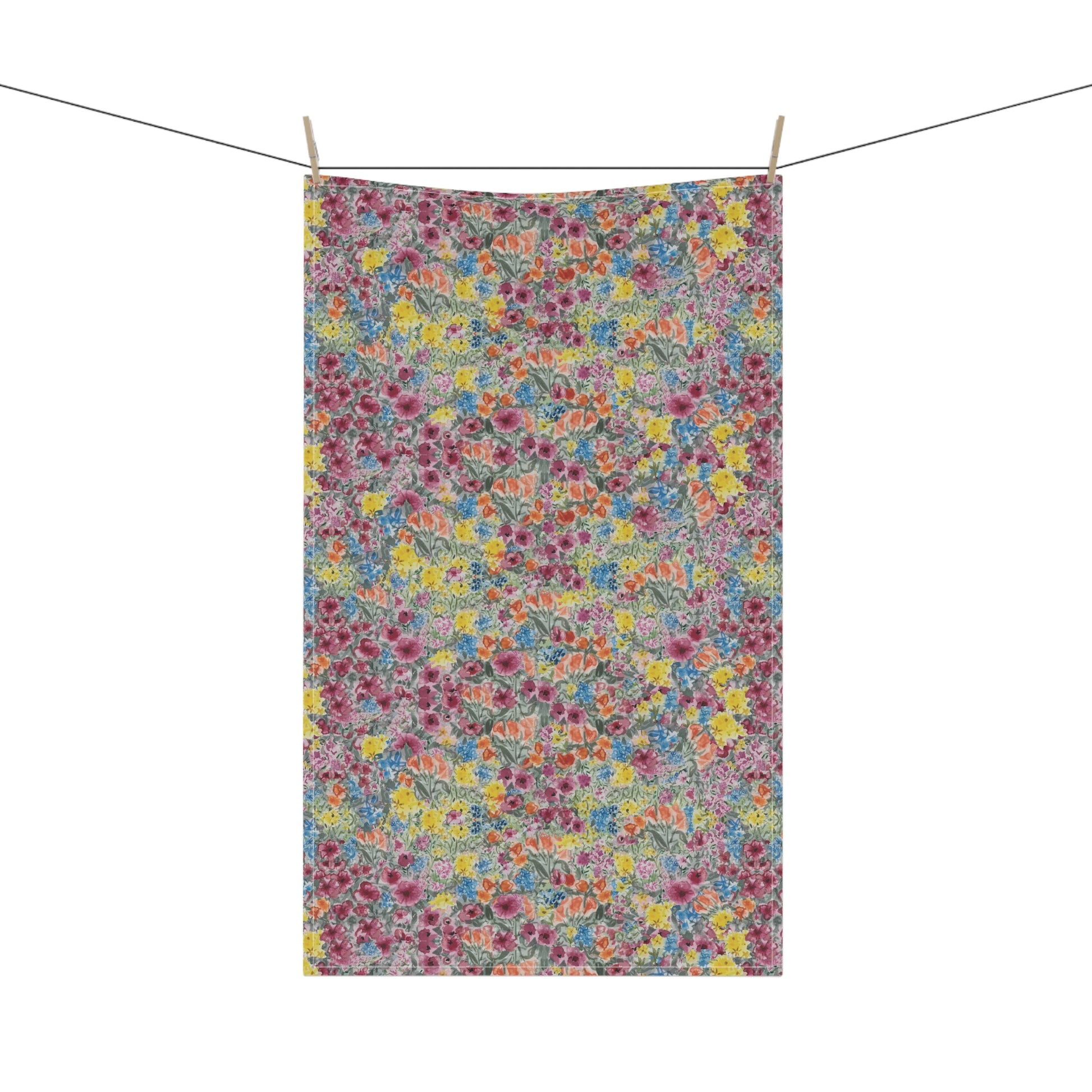 Floral patterned towel hanging on a line against a white background