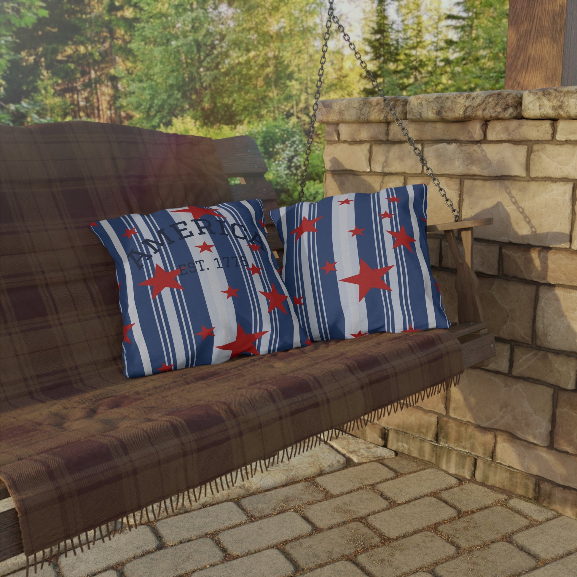 Wooden swing with striped cushions featuring red stars on a stone patio.