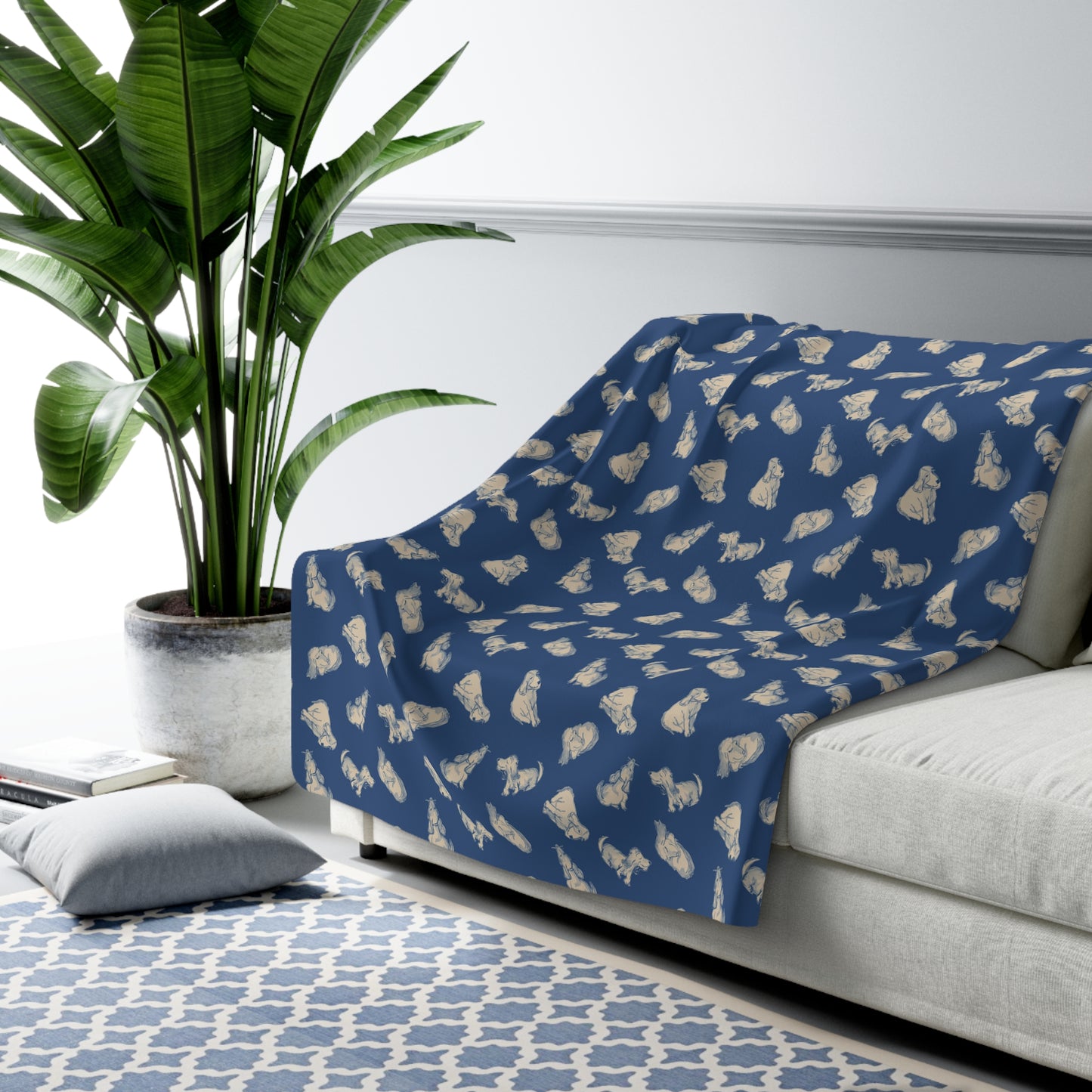Blue blanket with white patterns draped over a gray sofa in a living room setting.