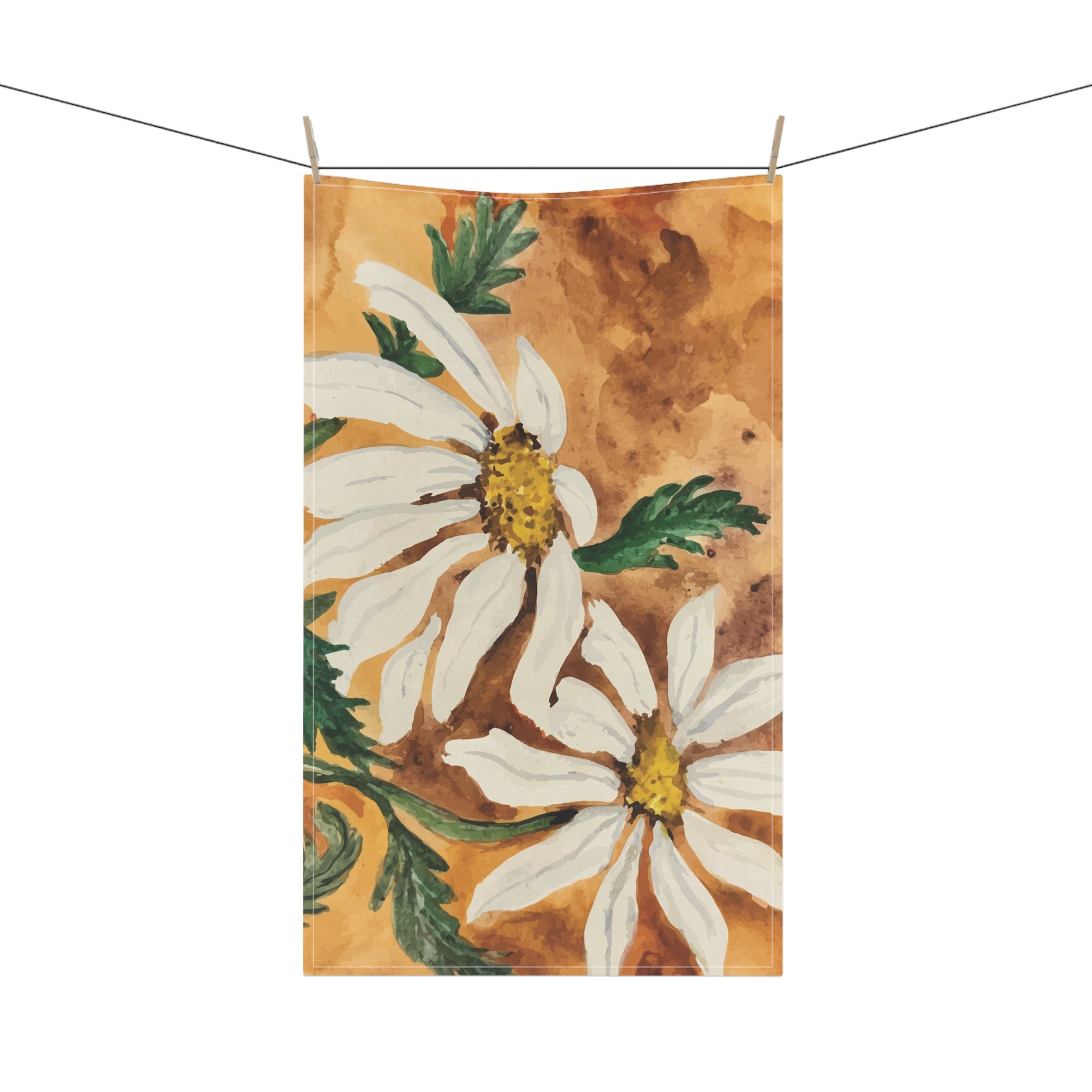 Watercolor daisy tea towel with white petals and golden centers on a warm orange background, displayed hanging in a bright kitchen.