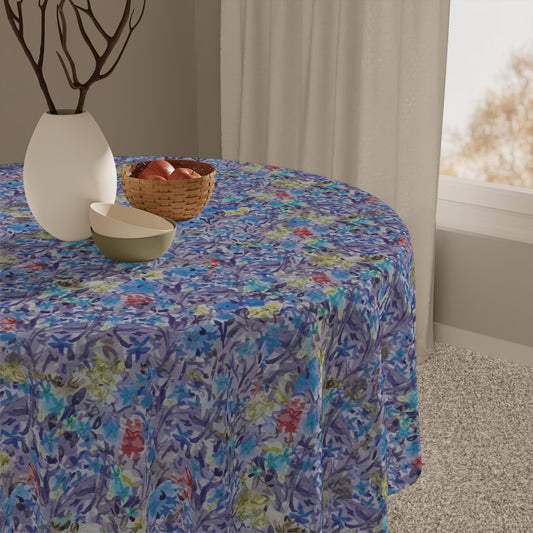 Round table with a floral tablecloth, vase, and bowl in a room setting.