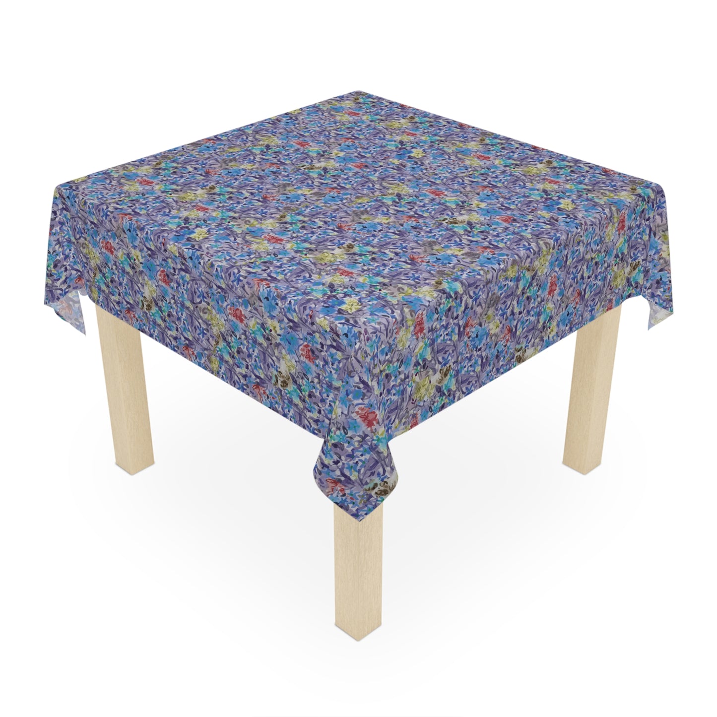 Round table covered with a blue watercolor floral tablecloth featuring botanical patterns in blue, lavender, and green tones.