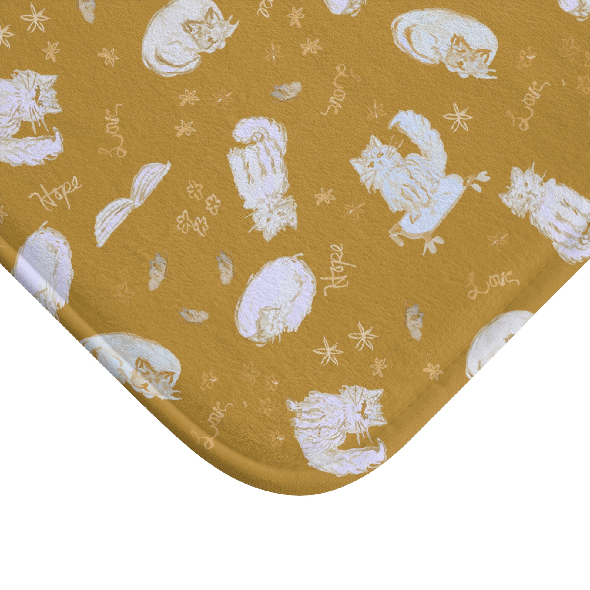 Mustard yellow bath mat featuring a cozy repeating pattern of sleeping and fluffy cats, books, stars, leaves, and handwritten words on a warm golden background, perfect for cat lovers and cozy home décor.