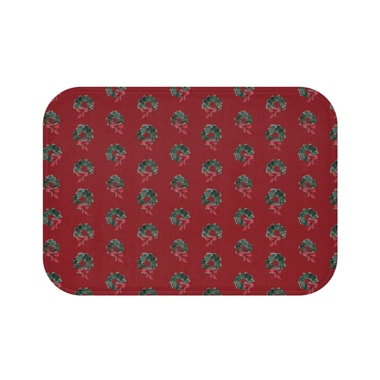 Bath mat with hand-painted evergreen wreaths on red