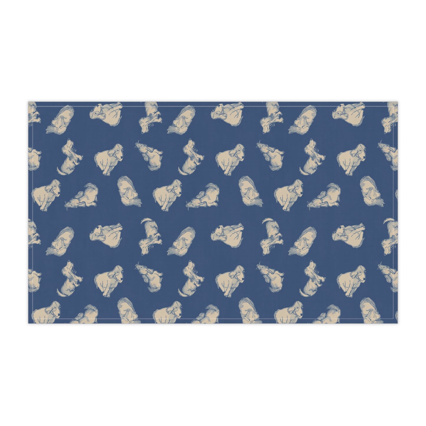 Navy blue kitchen tea towel featuring a repeating hand-drawn dog pattern in soft cream tones, displayed hanging in a bright kitchen with a wooden countertop, herbs, and fresh bread for cozy pet lover home décor.