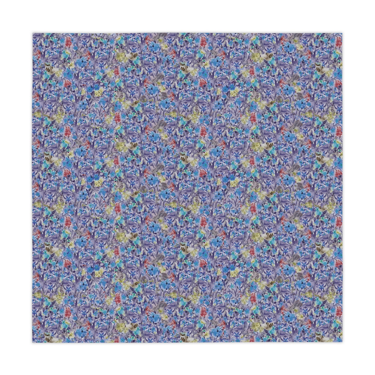 Round table covered with a blue watercolor floral tablecloth featuring botanical patterns in blue, lavender, and green tones.