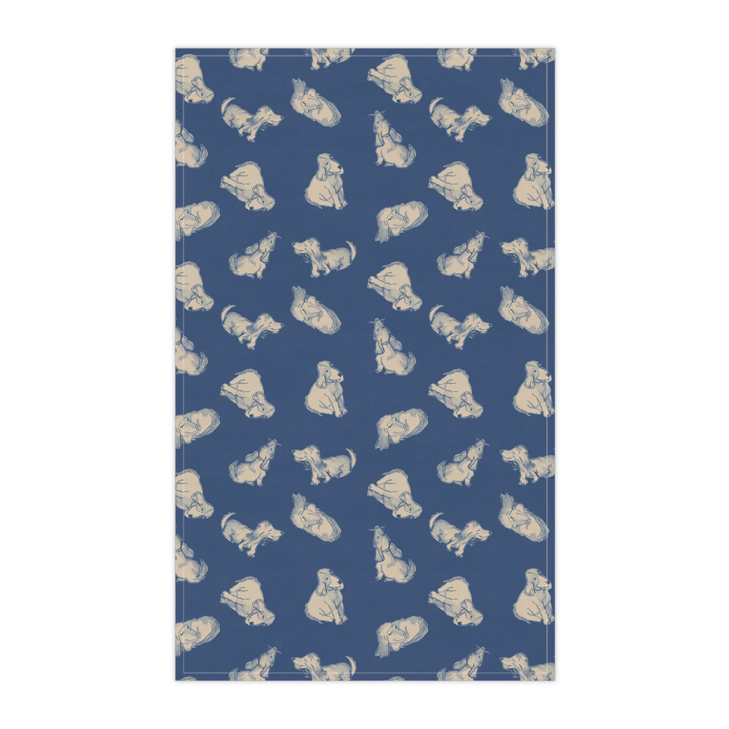 Navy blue kitchen tea towel featuring a repeating hand-drawn dog pattern in soft cream tones, displayed hanging in a bright kitchen with a wooden countertop, herbs, and fresh bread for cozy pet lover home décor.