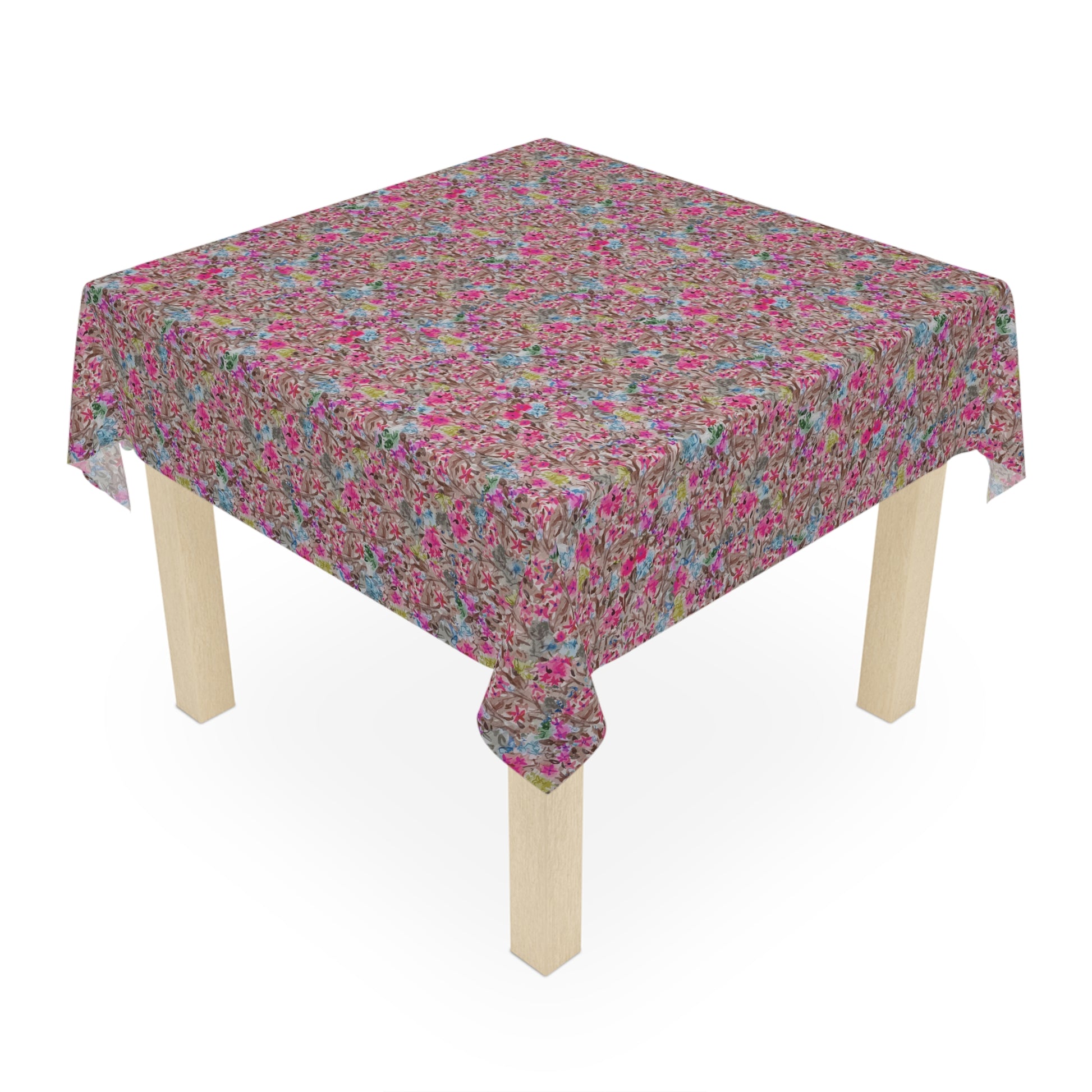 Small wooden table with a floral patterned tablecloth on a white . Modern floral table cover with bold pink blossoms and soft blue highlights background