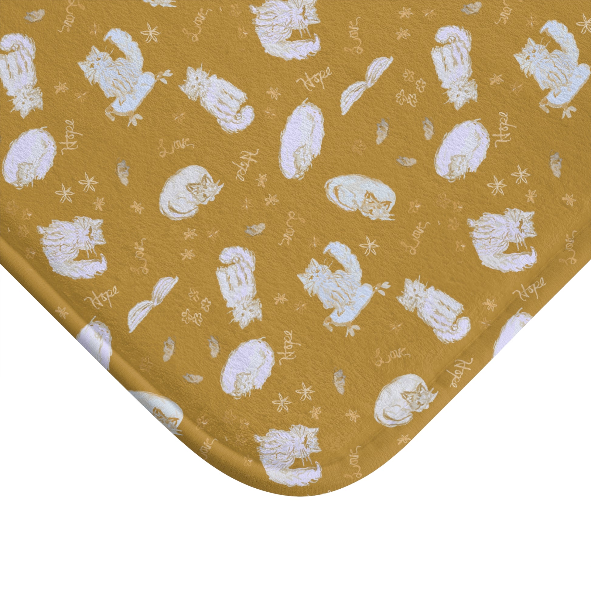 Mustard yellow bath mat featuring a cozy repeating pattern of sleeping and fluffy cats, books, stars, leaves, and handwritten words on a warm golden background, perfect for cat lovers and cozy home décor.
