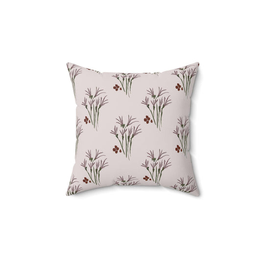 Square throw pillow with a repeating pattern of stylized purple floral sprigs and small red berries on a light pink background. The pillow has a soft, inviting appearance, suitable for home decor.