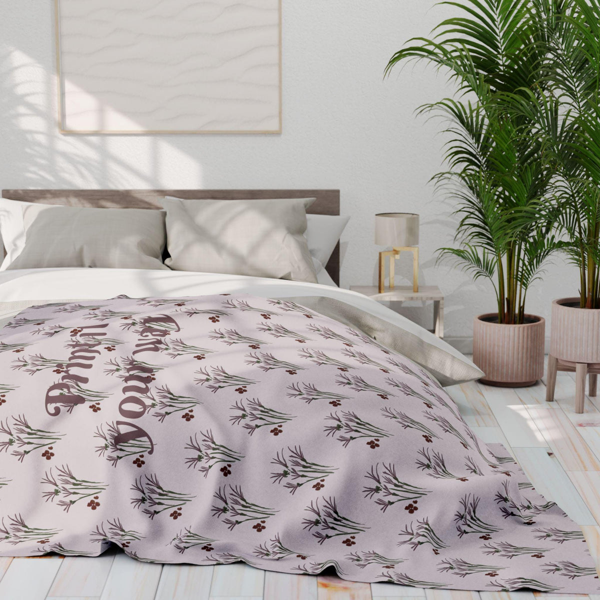 A light purple blanket with a repeating pattern of stylized sprigs and berries. The blanket is draped over a bed with white sheets and pillows. The words "Print Your Way" are printed on the blanket.