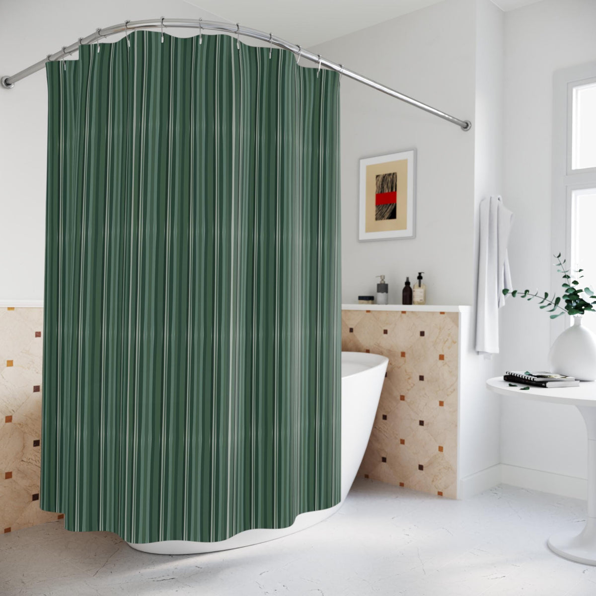 A green and white striped shower curtain hangs from a curved, silver-colored shower rod. The curtain is in front of a white bathtub. The bathroom has a neutral color scheme with a framed artwork and a small table.