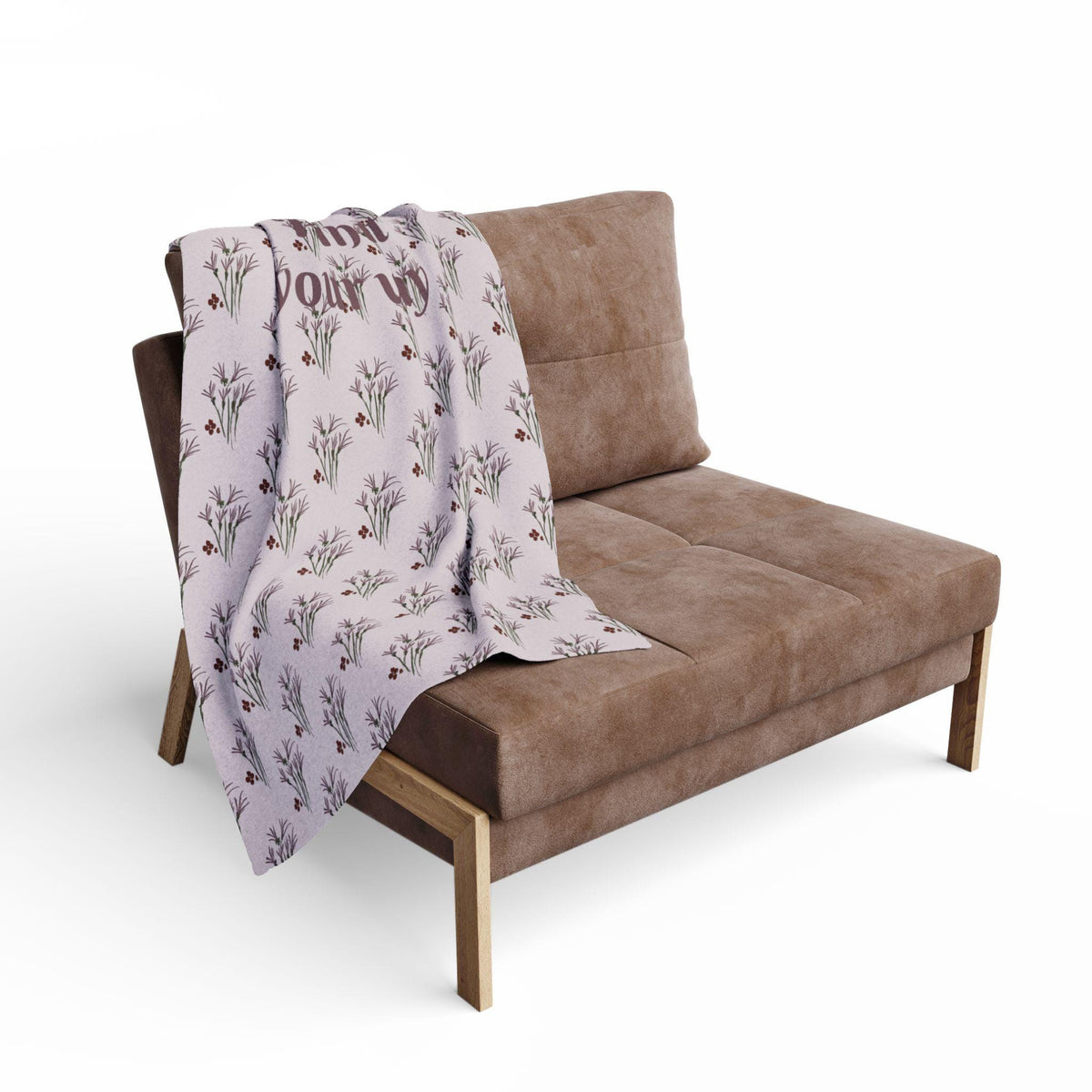 A brown upholstered chair with a light purple throw blanket draped over it. The blanket has a floral pattern with the words "Find Your Joy" printed on it in a dark brown color. The chair has wooden legs.