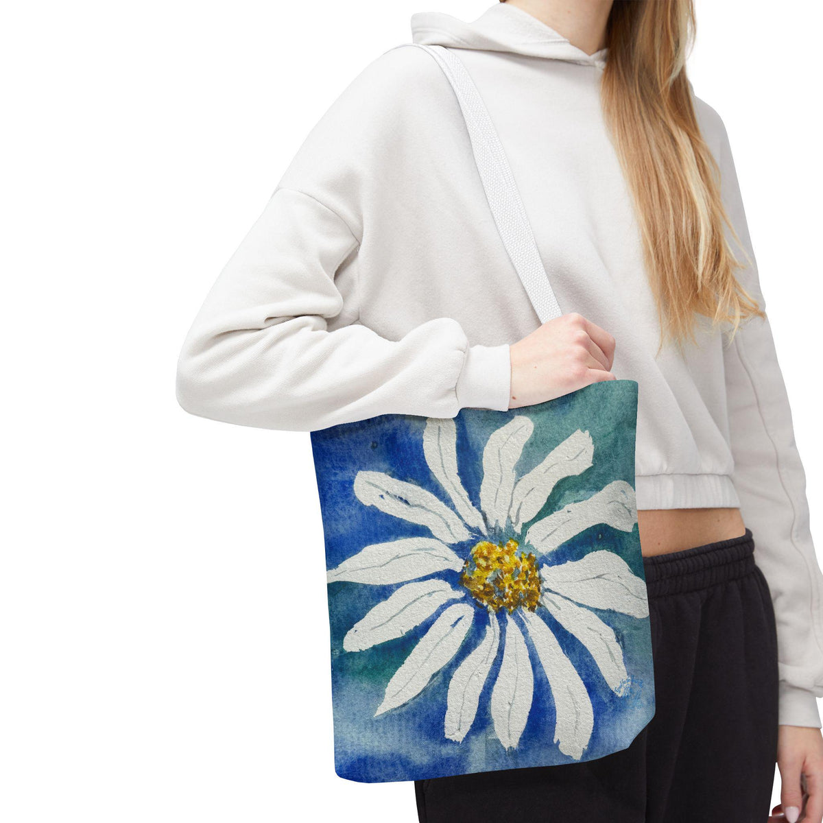 Watercolor daisy tote bag featuring a large hand-painted white daisy with a golden center on a deep blue and teal watercolor background, floral botanical shoulder bag designed from original artwork by Kathryn Young for Good For The Soul Art LLC.