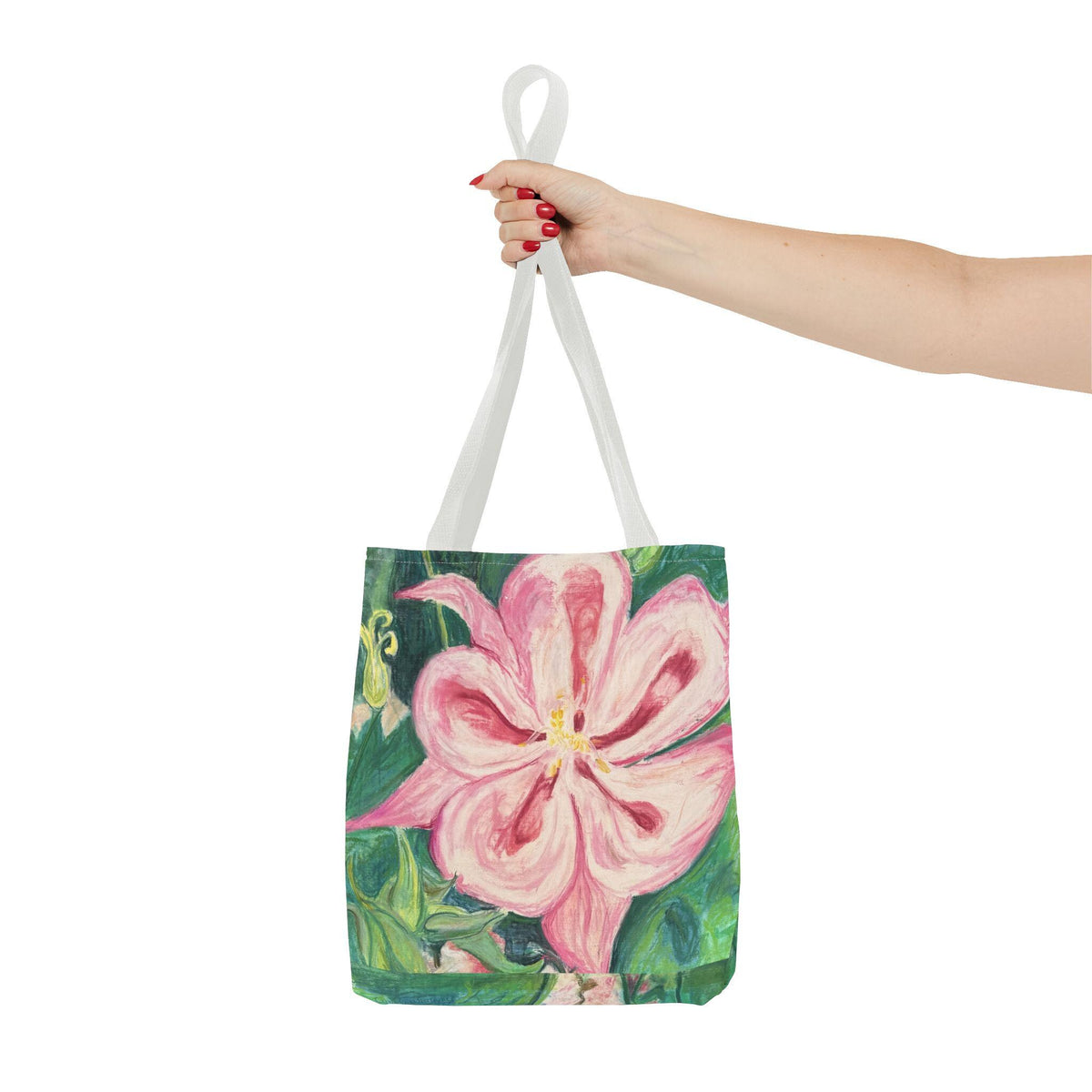 May include: A tote bag featuring a large pink flower painting with green foliage. The bag has white straps and is held up by a hand with red nail polish. The floral design is the focal point of the bag. Botanical art tote