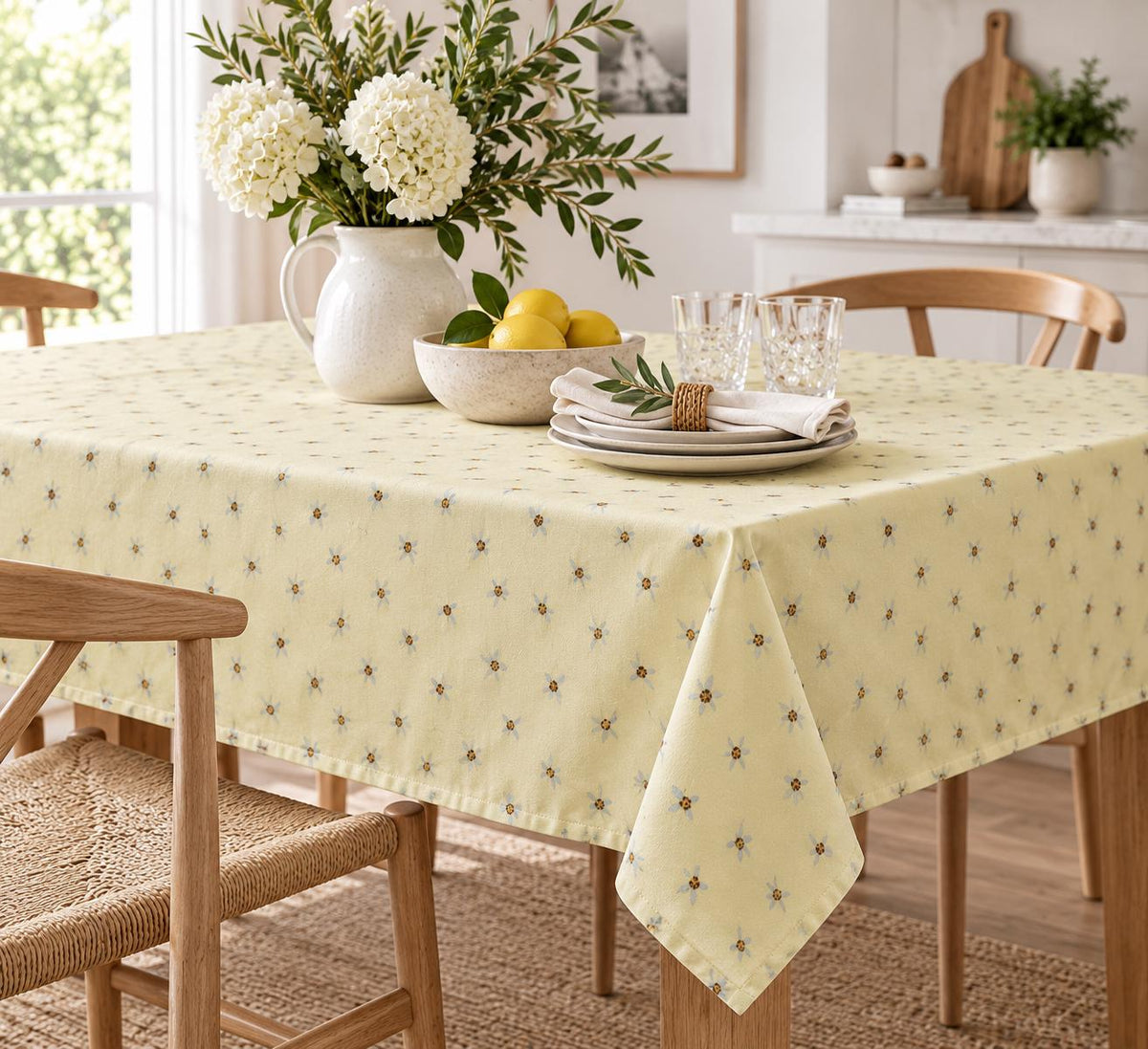 Cotton tablecloth with watercolor daisies and golden centers on soft butter yellow