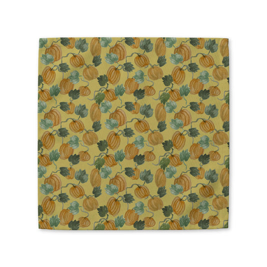 Cloth napkin with watercolor pumpkins and green vines on a golden yellow background, by Kathryn Young