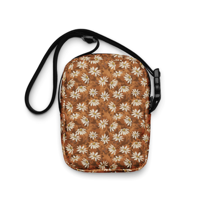 Daisy-scatter on textured warm browns bag with a black strap on a white background